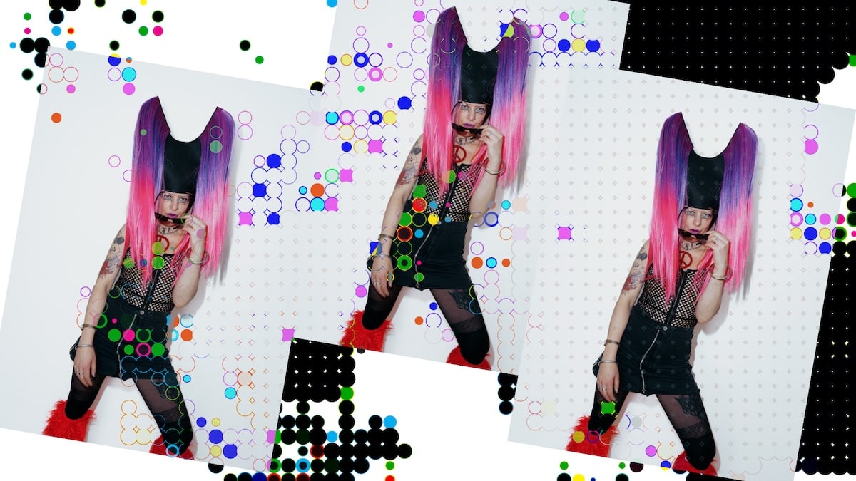 DJ Kat Kat Tat mit pink-schwarzem Haar und dunkler Kleidung vor einer grafischen Collage aus Punkten und bunten Kreisen